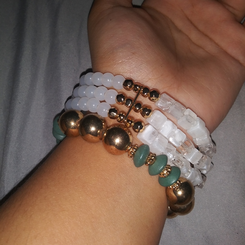 White beaded bracelet with faux gold. And green and gold elastic bracelet